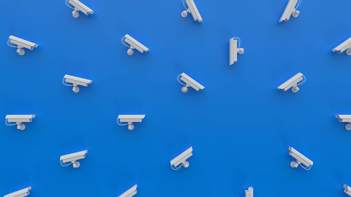 several white security cameras pointing at one area on blue background