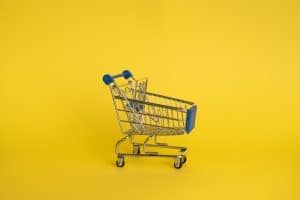 Picture of a small supermarket trolley on a yellow background