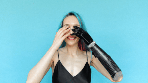 A female who has a prosthetic arm raising her hand to her head