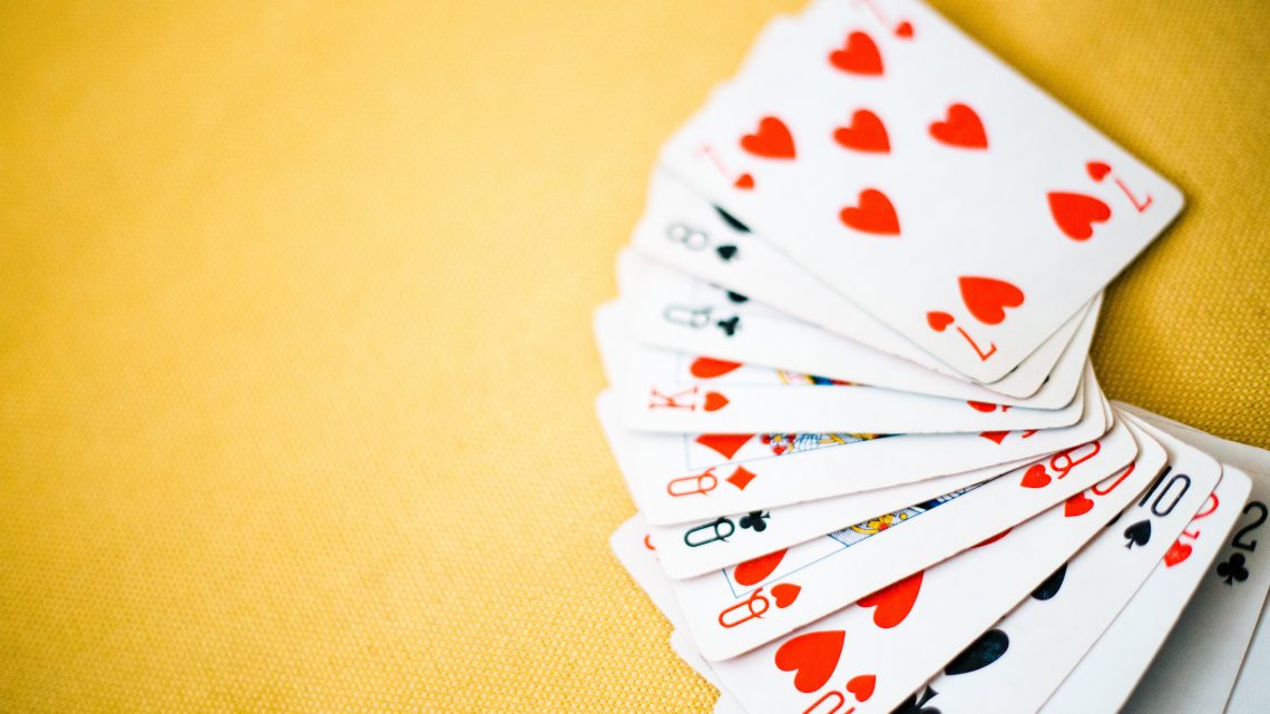 Playing cards spread out on a yellow table